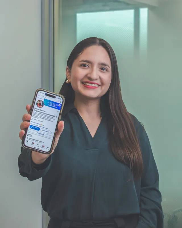 Brenda Ramirez mostrando en su celular la conversación de una persona asesorada que consiguió trabajo