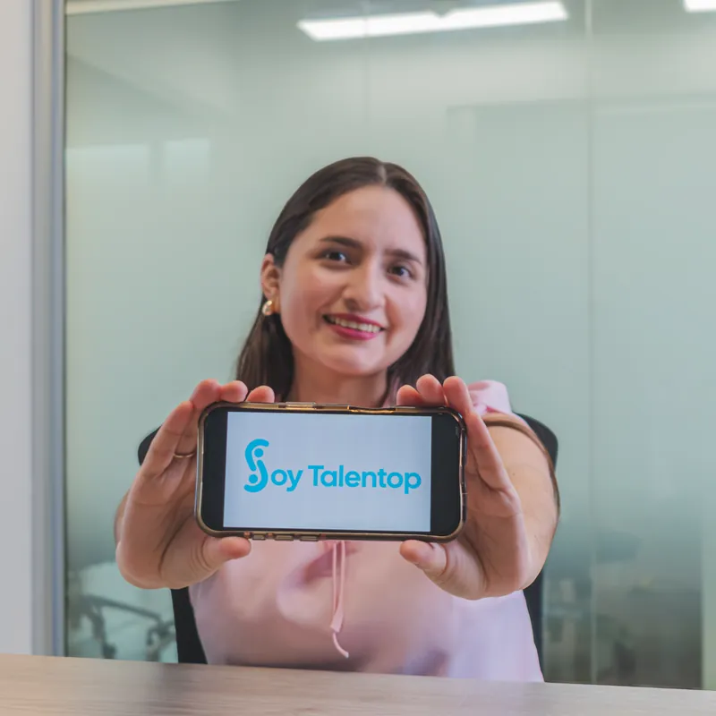 Brenda Ramirez sosteniendo un celular con el logo de Soy Talentop